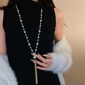 Elegant pearl tassel necklace styled with black turtleneck and white fuzzy sweater