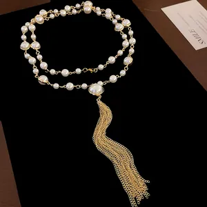 Close-up of elegant double-layer faux pearl necklace with long gold metal tassel.