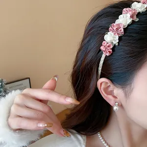 Detailansicht eines eleganten Blumen-Haarreifens am Modell mit rosa und weißen Blüten