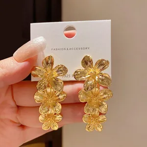 Eleganti orecchini pendenti a tre fiori dorati con ago in argento S925 su cartoncino