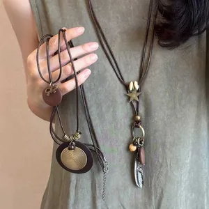 Vue détaillée du collier bohème ethnique avec perles de bois, plumes et étoiles.