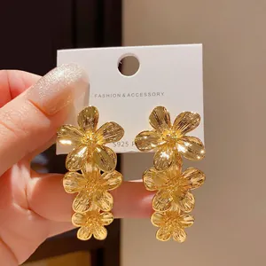 Orecchini a nappa con fiori dorati esagerati e un elegante design floreale a più strati