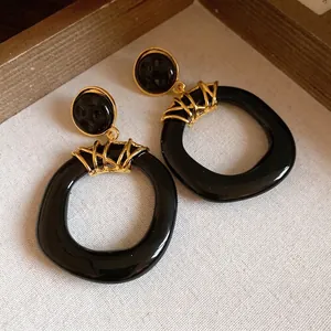 Orecchini a cerchio vintage in resina nera con eleganti dettagli in metallo dorato