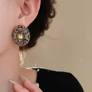 Orecchini a lobo ovali vintage dorati con strass e cristallo ambrato raffinati.