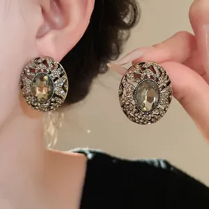 Orecchini ovali vintage con strass e finitura in argento antico indossati da modella