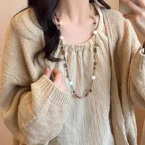 Collier de perles en bois vintage de style Zen avec pierres naturelles sur cardigan beige