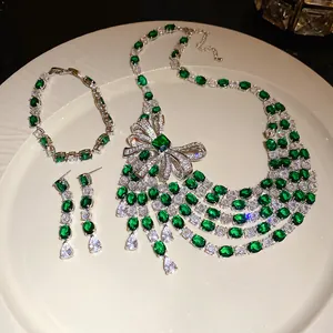 Gros plan sur un ensemble de bijoux en zircon vert émeraude avec collier et boucles.