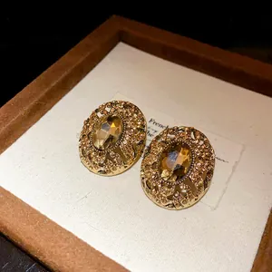 Primo piano di orecchini vintage ovali con strass ambrati e filigrana dorata