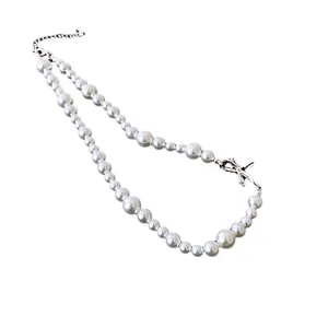 Elegant white pearl choker necklace with a polished silver bowknot pendant for women