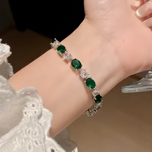 Détail d'un bracelet élégant en argent avec pierres d'émeraude et de zircon portées au poignet