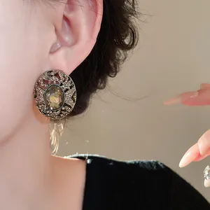 Dettaglio di orecchini vintage ovali in argento con cristallo fumé e strass brillanti