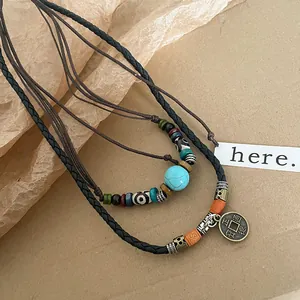 Vue détaillée de colliers ethniques avec turquoise et pendentif en pièce ancienne