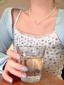 Model wearing an elegant zircon bow pearl necklace in a refreshing lifestyle shot