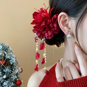 Elegant red fabric flower hair clip with delicate pearl tassels worn on a bun hairstyle
