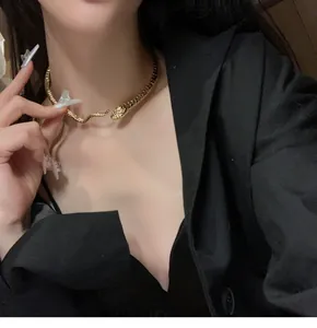 Primo piano di un girocollo a serpente in metallo dorato indossato da una modella