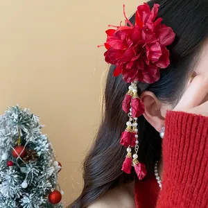 Detailed view of red fabric flower hair clip with elegant pearl tassels worn on hair
