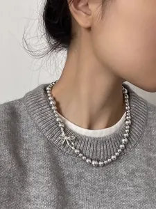 Detailed view of an elegant zircon bow pearl necklace worn on a model's neck for a stylish look.