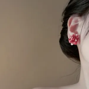 Macro detail view of elegant resin flower stud earring worn by an Asian model in soft light