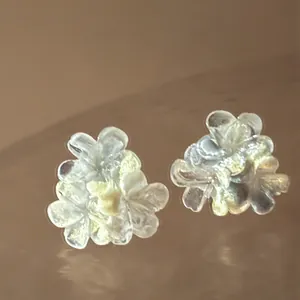 Macro detail of translucent resin flower stud earrings with soft pearlescent finish