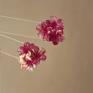 Detailed macro shot of deep red resin flower stud earrings with delicate petals.