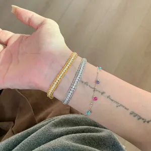 Elegant minimalist zircon tennis bracelet set on wrist with a colorful charm chain