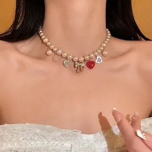Sweet pearl necklace with rhinestone heart and bow charms worn by a model in close-up view