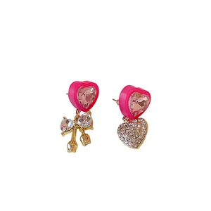 Sweet asymmetrical pink heart earrings with rhinestone bow and dangle heart details