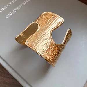 Squisito bracciale rigido dorato strutturato minimalista con design cavo aperto