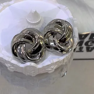 Close-up of vintage twisted flower stud earrings with a shiny silver metallic finish