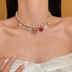Detailed shot of a sweet pink pearl choker necklace featuring heart and bow pendants