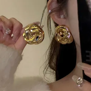 Close-up detail of vintage French style gold twisted metal flower stud earrings for fashion women