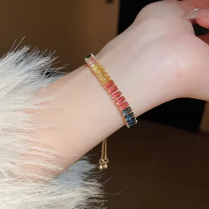 Gros plan d'un bracelet vibrant en zircon arc-en-ciel au poignet avec manche douce