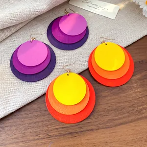 Close-up detail of stylish layered round wooden pendant earrings in vibrant colors