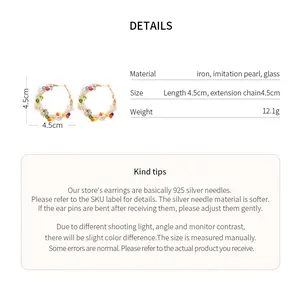 Detalle de pendientes de aro con cuentas de colores y agujas de plata 925