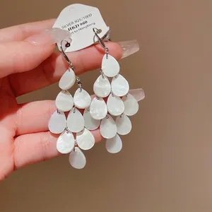 Elegant tiered white teardrop tassel earrings with shell luster in minimalist style