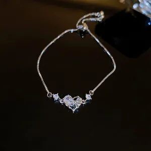 Elegant silver bracelet featuring a heart-shaped zircon and bow detail, adjustable chain.