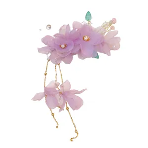 Barrette à fleurs en tissu violet avec perles et élégants pompons en chaîne dorée.