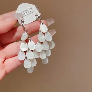 Elegant teardrop tassel earrings featuring a luminous mother-of-pearl finish macro view