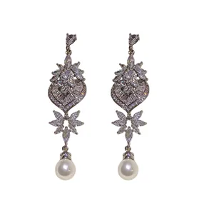 Eleganti orecchini a forma di cuore e foglia con strass e perle su sfondo bianco