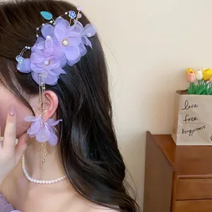 Vue détaillée de la pince à cheveux fleur en tissu violet avec glands en perles élégants.