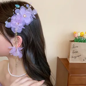 Détail d'une barrette à cheveux à fleurs en tissu violet avec d'élégants glands en perles