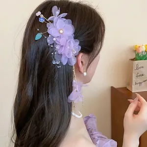 Vue détaillée d'une pince à cheveux fleur en tissu violet avec perles et franges