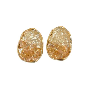 Elegant oval stud earrings with orange and white crushed crystal inlay in gold frame