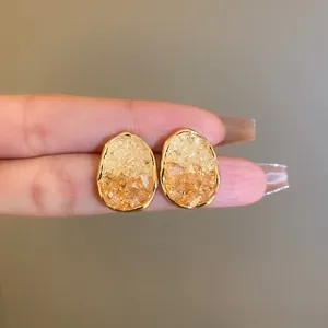 Detailed view of elegant crystal oval geometric stud earrings with gold-plated edges