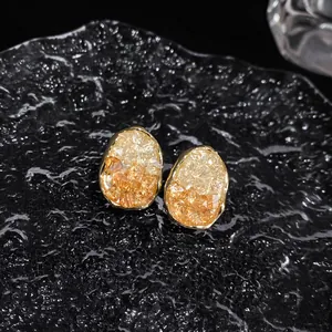 Macro detail view of elegant oval geometric earrings with faceted amber gradient crystals