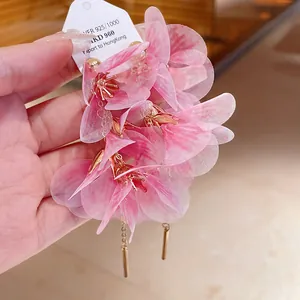 Detailed close-up of pink mesh flower earrings featuring delicate layered fabric petals
