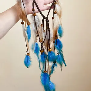 Detailed macro view of handmade bohemian hairband with blue feathers and wooden beads