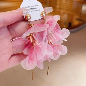 Detailed view of handmade pink gauze flower petal earrings with shimmering gold accents