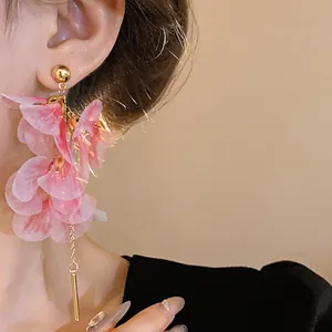 Close-up of elegant pink mesh floral earrings with long gold chain dangles and silver needles