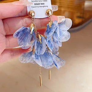 Close-up of elegant blue mesh flower earrings with silver needles and gold accents